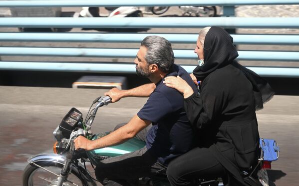 Un bărbat și o femeie pe o motocicletă pe o stradă din Teheran. - Sputnik Moldova-România