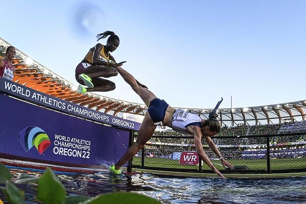 Француженка Алиса Фино падает в воду во время участия в финале забега на 3000 метров с препятствиями на чемпионате мира по легкой атлетике на Хейворд Филд в Юджине, США. - Sputnik Молдова