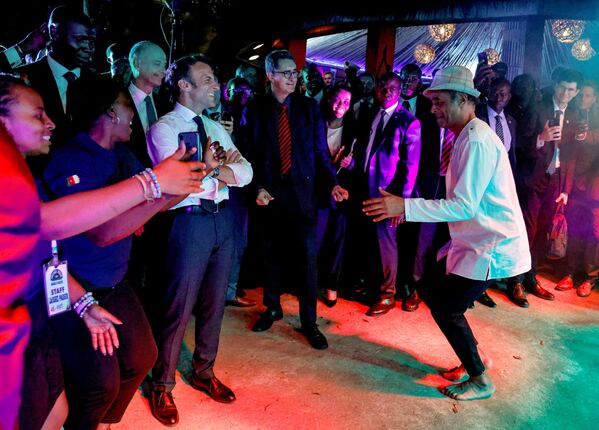Французский теннисист Янник Ноа танцует рядом с президентом Франции Эммануэлем Макроном во время вечеринки в районе Этуди, Яунде, Камерун. - Sputnik Молдова