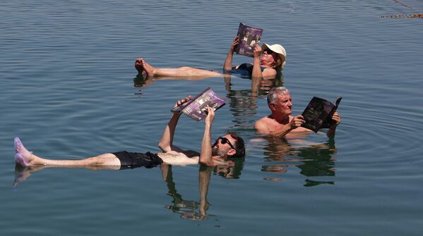 Члены жюри Международного кинофестиваля в Аммане изучают каталог фестиваля, плавая в Мертвом море. - Sputnik Молдова