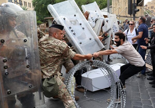 Ливанские активисты противостоят солдатам, охраняющим вход в здание парламента страны во время демонстрации в центре Бейрута. - Sputnik Молдова