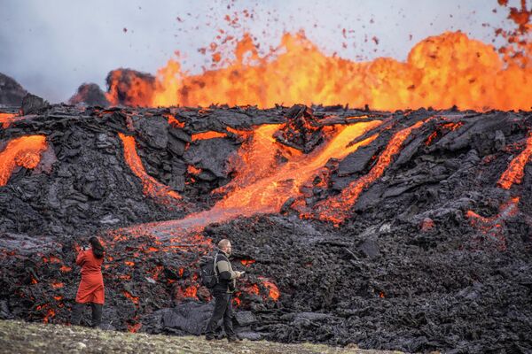 Люди смотрят на потоки лавы на вулкане Фаградальсфьялль в Исландии. - Sputnik Молдова