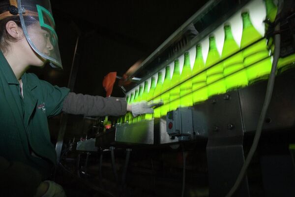 Рабочий проверяет бутылки с пивом на пивоварне Harbin, Китай. - Sputnik Молдова