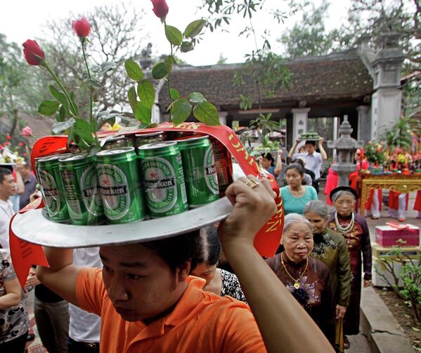Мужчина несет банки пива  к алтарю во время фестиваля Kim Lien Temple в Ханое, Вьетнам. - Sputnik Молдова