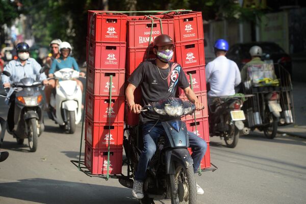 Мужчина везёт ящики с пивом на мопеде на улице в Ханое, Вьетнам. - Sputnik Молдова