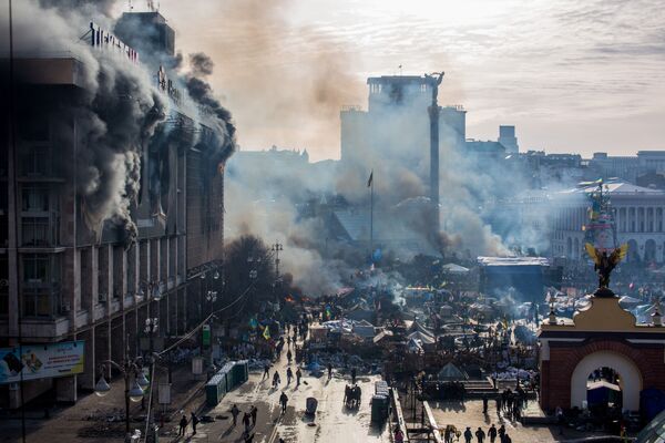 În fotografie este surprins fumul de la incendii și susținătorii opoziției, în Piața Independenței din Kiev - Sputnik Moldova