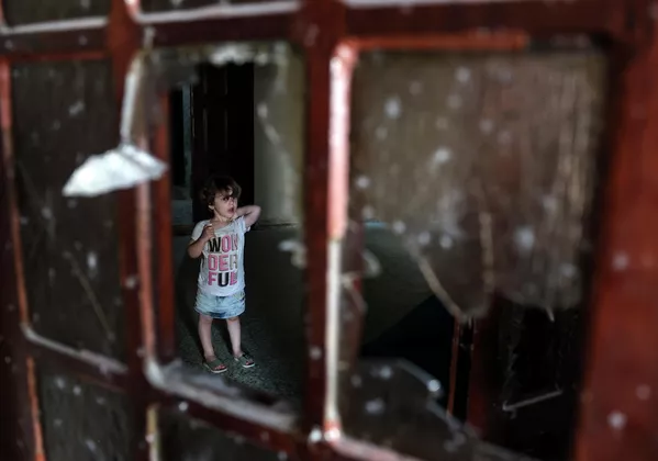 Un copil palestinian stă în spatele unei ferestre sparte în interiorul unei clădiri avariate în urma atacurilor aeriene israeliene de la Rafah, în sudul Fâșiei Gaza, pe 7 august 2022. Un copil palestinian stă în spatele unei ferestre sparte în interiorul unei clădiri avariate în urma atacurilor aeriene israeliene de la Rafah, în sudul Fâșiei Gaza, pe 7 august 2022. - Sputnik Moldova-România
