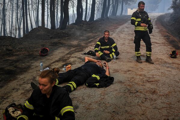 Pompierii beau apă și se recuperează în timpul unei operațiuni de oprire a unui incendiu din satul Sameiro, lângă orașul Manteigas, pe 10 august 2022. - Un incendiu care a izbucnit sâmbătă a făcut ravagii în parcul natural Serra da Estrela din centrul Portugaliei . - Sputnik Moldova-România