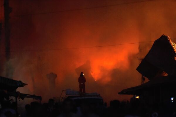 Тушение пожара продолжается в вечернее время на месте разрушенного взрывом торгового центра Сурмалу в Ереване - Sputnik Молдова