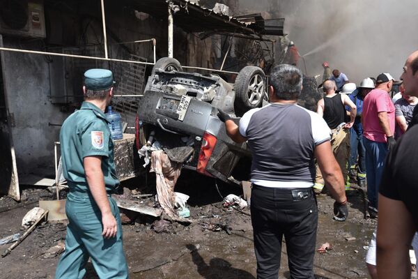 Разрушения и перевернутый автомобиль на месте взрыва у торгового центра Сурмалу в Ереване - Sputnik Молдова