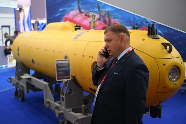 Un vizitator vorbește la telefon lângă un model de submarin la expoziția din cadrul Forumului Tehnic Militar Internațional Army-2022 de la Centrul de Expoziție Patriot. - Sputnik Moldova