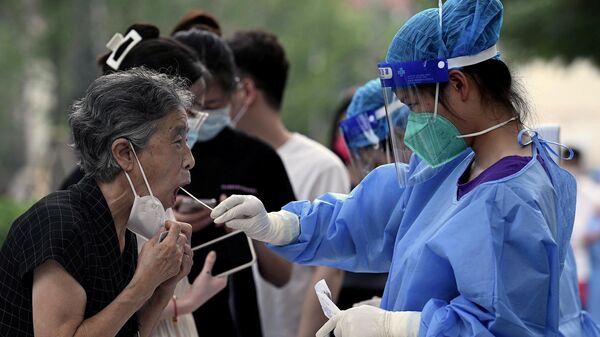 O femeie este prelevată pentru testarea Covid-19 la un loc de colectare a tamponului din Beijing - Sputnik Moldova-România