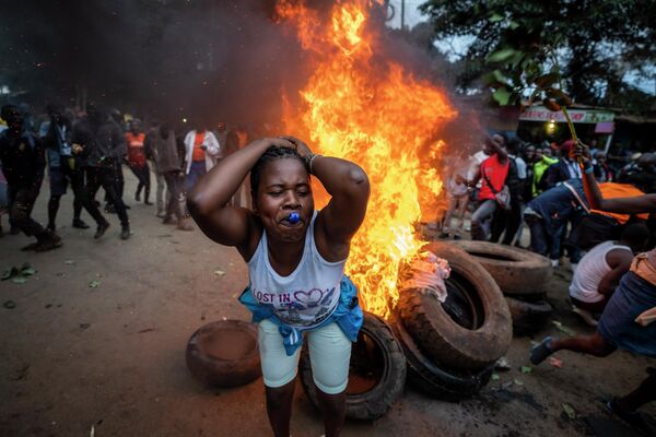 Сторонница кандидата в президенты во время акции протеста рядом с блокпостом из горящих шин в Найроби, Кения  - Sputnik Молдова
