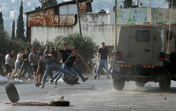 Палестинские подростки бросают камни в армейские машины  - Sputnik Молдова