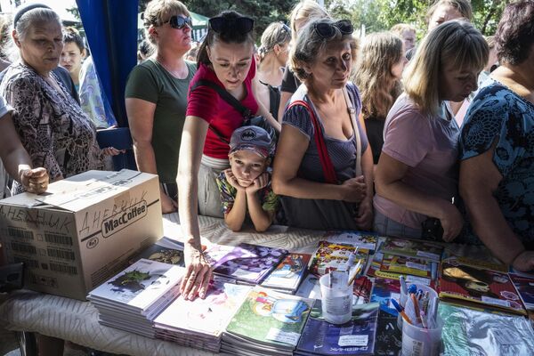 Oamenii fac coadă pentru a procura produse de papetărie la un târg școlar din Mariupol. - Sputnik Moldova-România