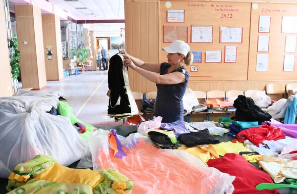 Un angajat al liceului nr. 14 sortează haine pentru copii  în timpul pregătirilor școlii pentru noul an de studii. - Sputnik Moldova-România