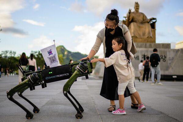 Маленькая девочка и ее мать взаимодействуют с &quot;собакой-роботом&quot; в Сеуле. - Sputnik Молдова