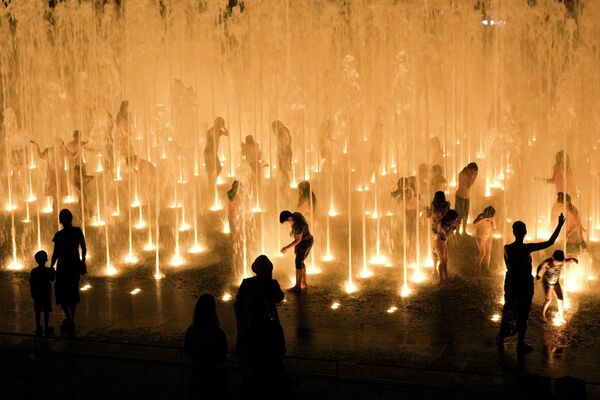 Горожане освежаются в фонтане рядом со Старым городом в Иерусалиме во время сильной жары. - Sputnik Молдова