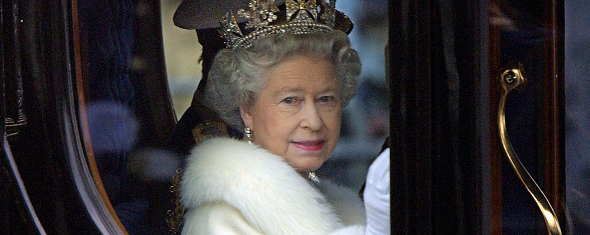 Королева Елизавета II приветствует толпу из своей конной повозки, когда она покидает Букингемский дворец на открытие парламента в Лондоне, 6 декабря 2000 года - Sputnik Молдова, 1920, 09.09.2022