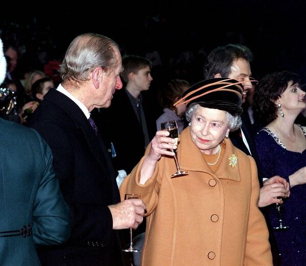 Королева Великобритании Елизавета II (справа) поднимает бокал с шампанским в сторону своего мужа, герцога Эдинбургского, чтобы произнести тост за новое тысячелетие незадолго до полуночи 31 декабря 1999 года.  - Sputnik Молдова