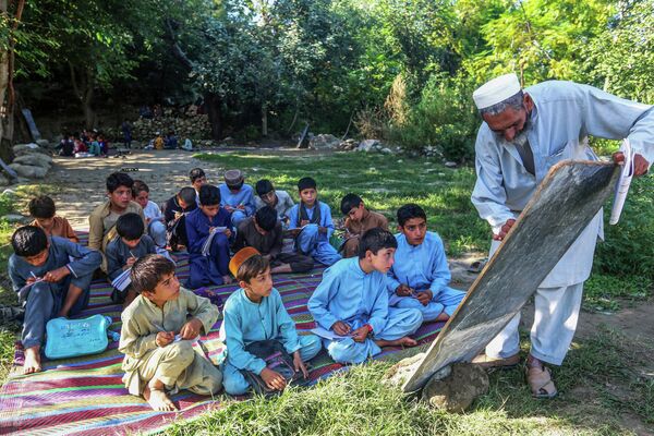 Афганские дети посещают занятия в школе под открытым небом в районе Ачин - Sputnik Молдова