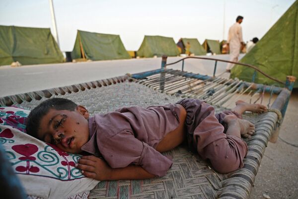 Комнатные мухи сидят на лице пострадавшего от наводнения мальчика, Пакистан  - Sputnik Молдова