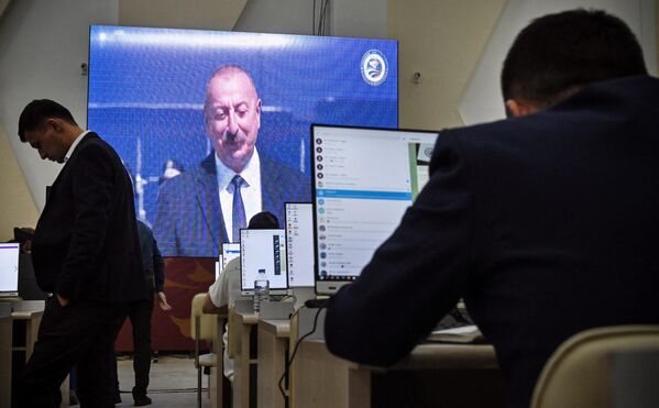 Jurnaliştii urmăresc transmisiunea în direct a sosirii preşedintelui Azerbaidjanului, Ilham Aliyev, la Samarkand, pe 15 septembrie 2022, în centrul de presă al Summit-ului. - Sputnik Moldova-România