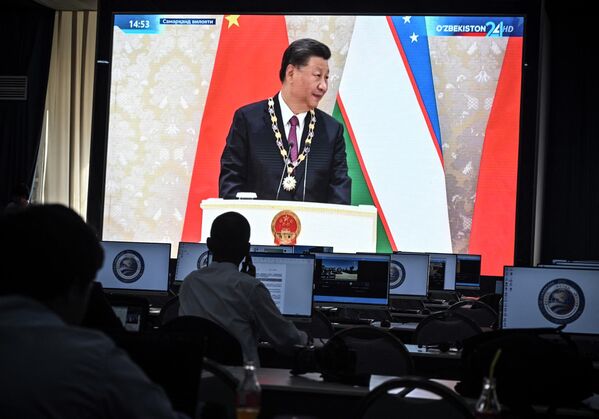 Jurnaliştii urmăresc transmisiunea în direct a sosirii lui Xi Jinping din China la Samarkand pe 15 septembrie 2022, în centrul de presă al Summit-ului. - Sputnik Moldova-România