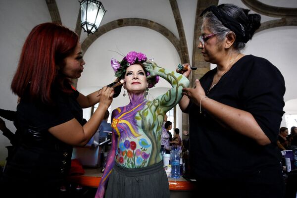 Художники раскрашивают тело женщины, победившей рак молочной железы, в рамках акции A brushstroke for life в Гвадалахаре, Мексика. - Sputnik Молдова