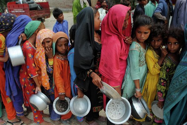 Люди из пострадавших от наводнения районов ждут раздачи еды благотворительным фондом Saylani Welfare Trust, в Лал-Баге, провинция Синд, Пакистан. - Sputnik Молдова