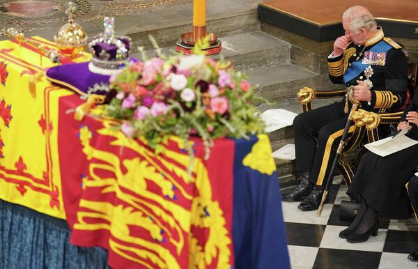 Король Великобритании Карл III (справа) сидит перед гробом королевы Елизаветы II во время ее государственных похорон в Вестминстерском аббатстве в Лондоне 19 сентября 2022 года. - Sputnik Молдова