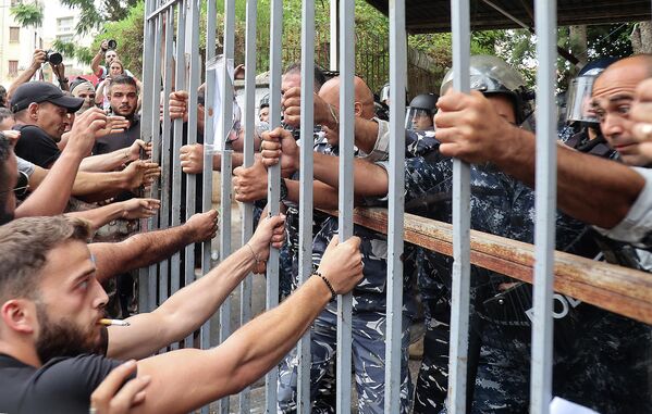 Протестующие пытаются сломать ворота, ведущие во Дворец правосудия в столице Ливана Бейруте, 19 сентября 2022 года, требуя освобождения двух человек, причастных к ограблению банка на прошлой неделе.  - Sputnik Молдова