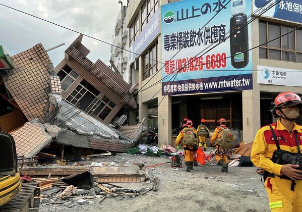 На этом фото, предоставленном пожарной службой округа Хуалянь, показаны пожарные, ищущие жертв в обрушившемся жилом доме после землетрясения в поселке Юйли округа Хуалянь, восточный Тайвань, в воскресенье, 18 сентября 2022 года.  - Sputnik Молдова