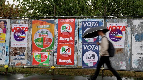 Мужчина проходит мимо предвыборных плакатов в Милане - Sputnik Молдова