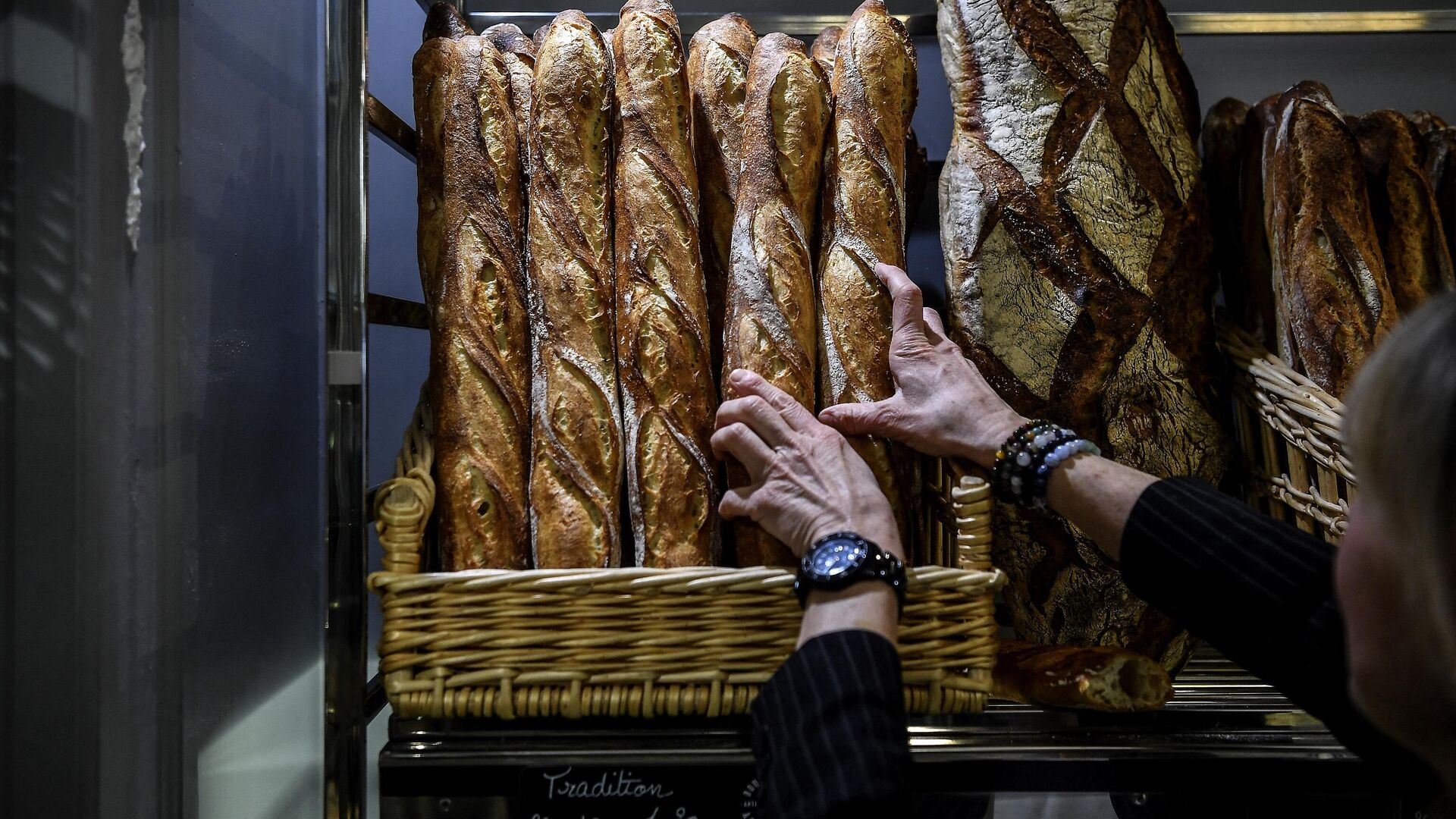 Покупатель выбирает хлеб в булочной в Париже - Sputnik Moldova-România, 1920, 27.09.2022