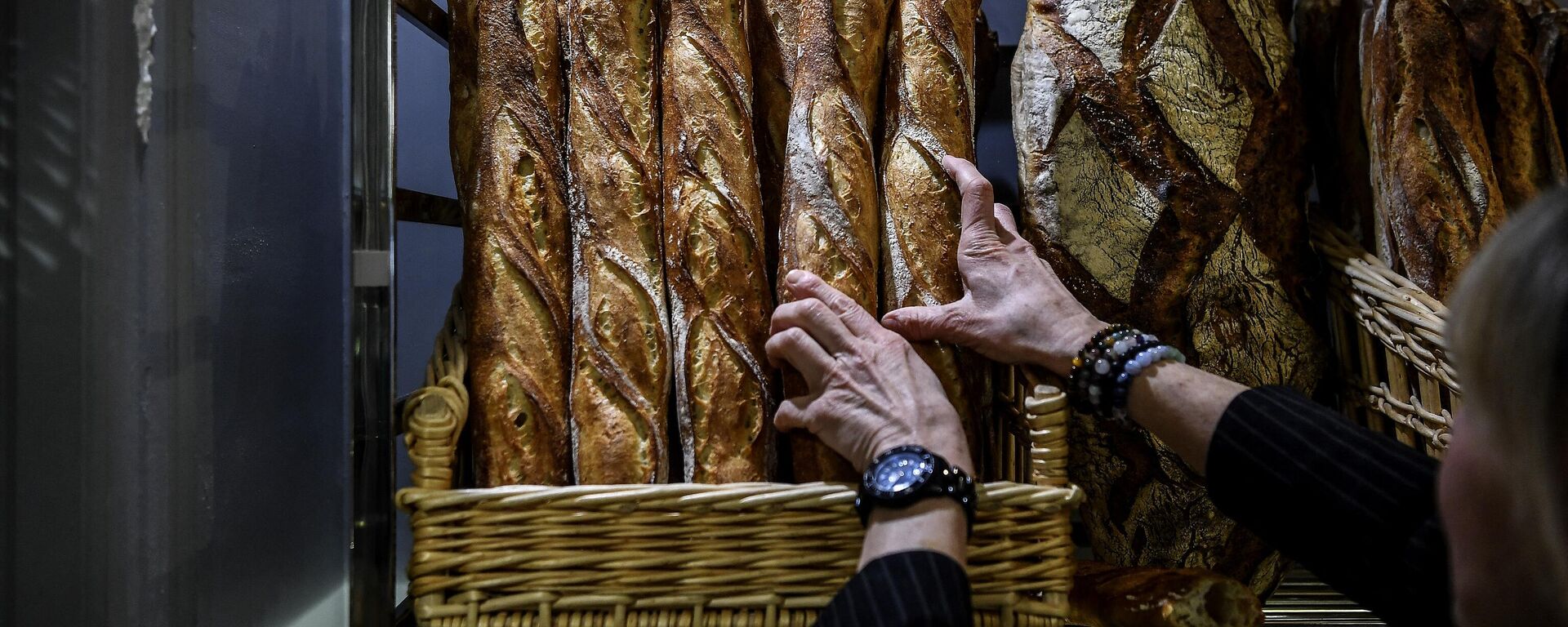 Покупатель выбирает хлеб в булочной в Париже - Sputnik Moldova-România, 1920, 27.09.2022