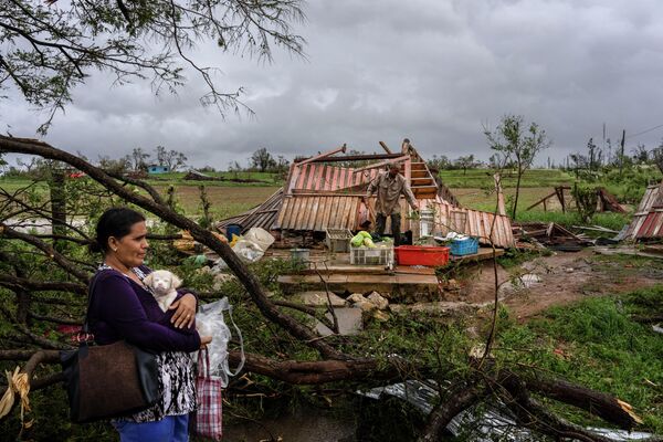Mercedes Valdez își ține în brațe câinele Kira în timp ce așteaptă transportul după ce și-a pierdut casa din cauza uraganului Ian în Pinar del Rio, Cuba, marți, 27 septembrie 2022. - Sputnik Moldova-România