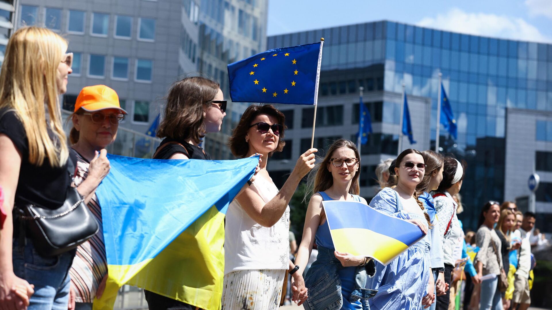 Manifestanții țin steaguri ucrainene în timpul unui miting în fața sediului Comisiei Europene de la Bruxelles - Sputnik Moldova-România, 1920, 06.10.2022