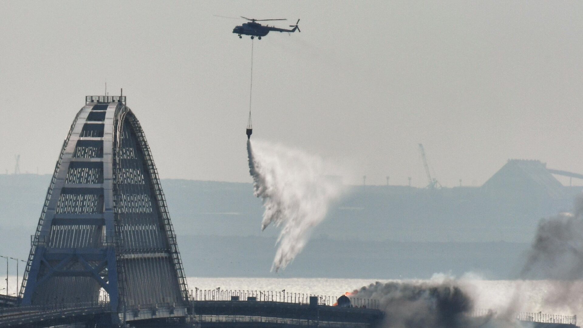 Вертолет тушит пожар на Крымском мосту, на автомобильной части которого со стороны Таманского полуострова произошел подрыв грузового автомобиля, повлекший за собой возгорание семи топливных цистерн железнодорожного состава - Sputnik Moldova, 1920, 08.10.2022