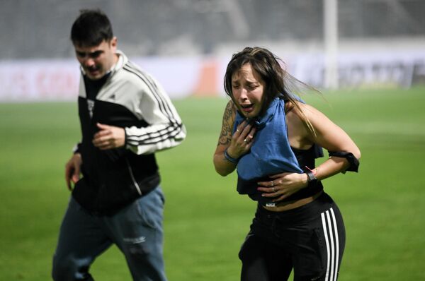 Болельщики футбольной команды Gimnasia de La Plata задыхаются от слезоточивого газа, распылённого полицией во время матча местного турнира в Ла-Плате, Аргентина - Sputnik Молдова