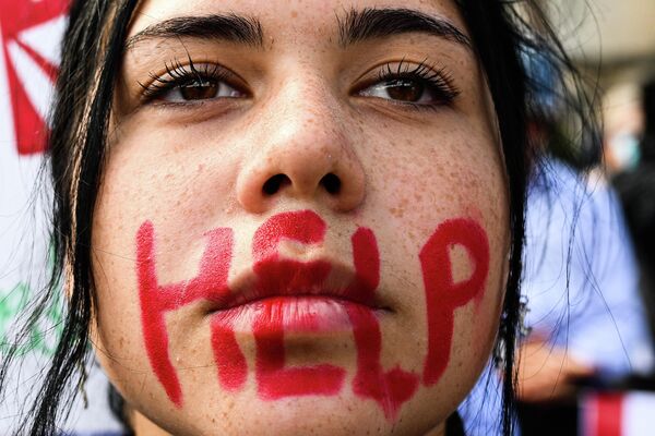 Молодая женщина с надписью HELP на лице принимает участие в акции протеста в Риме в память о смерти курдской женщины Махсы Амини в Иране - Sputnik Молдова
