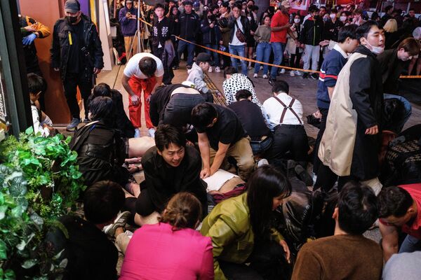 Прохожие пытаются реанимировать пострадавших в массовой давке во время празднования Хэллоуина в Сеуле, Южная Корея - Sputnik Молдова