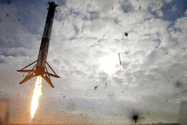 Левый и задний ускорители ракеты SpaceX Falcon Heavy возвращаются на мыс Канаверал для посадки, примерно через восемь минут после старта, штат Флорида, США - Sputnik Молдова