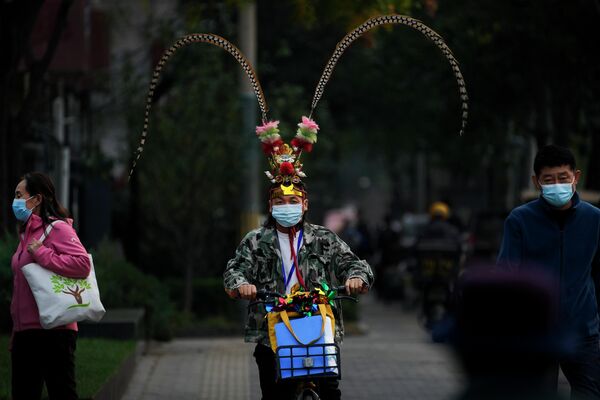 Мужчина в головном уборе Короля обезьян на улице в Пекине, Китай - Sputnik Молдова