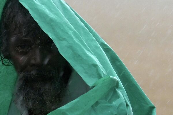 Мужчина под полиэтиленовой пленкой во время сильного муссонного дождя в Ченнаи, Индия - Sputnik Молдова