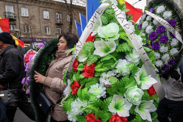 După protest, oamenii s-au îndreptat spre clădirea Preşedinţiei pentru a depune coroane artificiale de flori și au dus un panou cu inscripția: „PAS ucide speranțele moldovenilor” - Sputnik Moldova