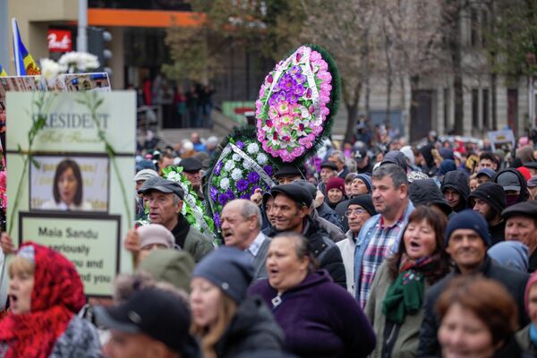 După protest, oamenii s-au îndreptat spre clădirea Preşedinţiei pentru a depune coroane artificiale de flori și au dus un panou cu inscripția: „PAS ucide speranțele moldovenilor” - Sputnik Moldova