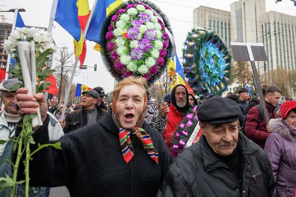 După protest, oamenii s-au îndreptat spre clădirea Preşedinţiei pentru a depune coroane de flori artificiale și au dus un panou cu inscripția: „PAS ucide speranțele moldovenilor” - Sputnik Moldova