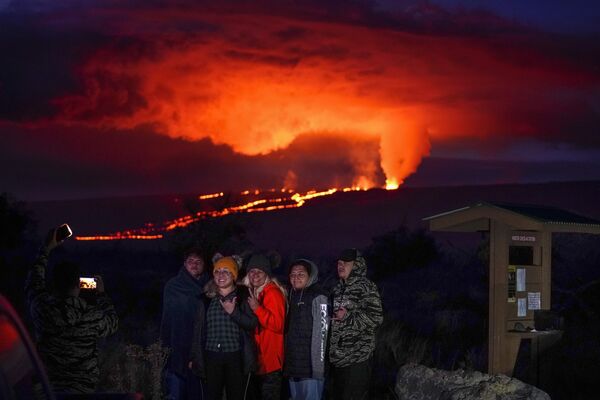 Люди позируют на фоне извержения лавы из вулкана Мауна-Лоа на Гавайях - Sputnik Молдова
