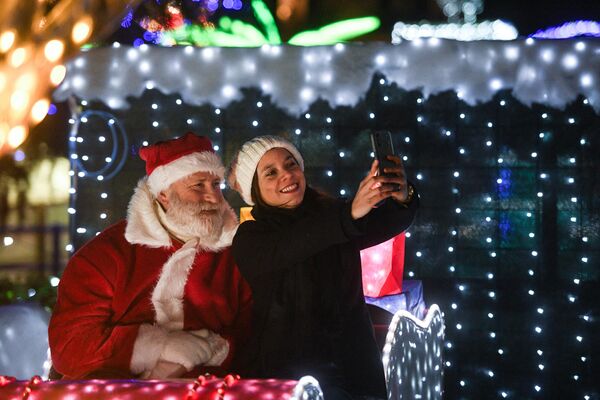 Человек в костюме Санта-Клауса фотографируется с девушкой в Италии. - Sputnik Молдова